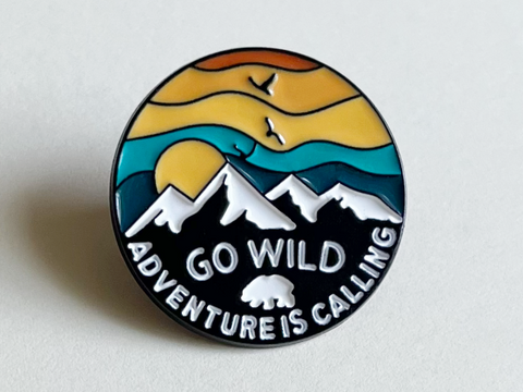 Camping Pin with Mountains and Sky Scene with Saying "Go Wild Adventure is Calling"