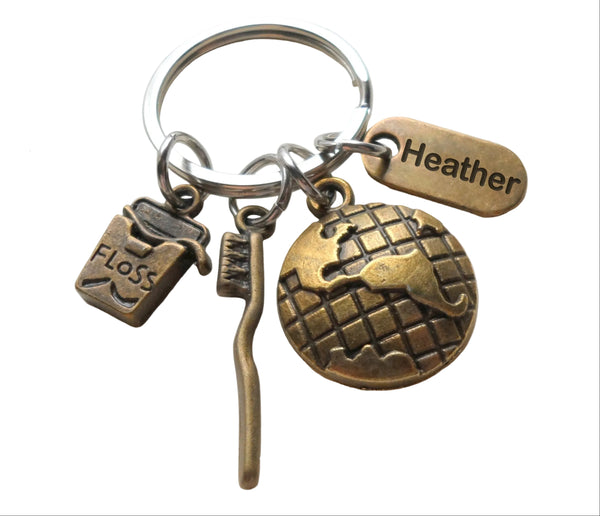 Custom Dental Assistant, Dental Office Staff, Orthodontics Employee Thank You Keychain; Bronze Toothbrush, Floss & Globe Charm Keychain with Personalized Tag by JewelryEveryday