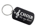 A black dog-tag style keychain with a silver metal key ring, featuring the white text 'CHOIR has my heart' and a white treble clef symbol, shown on a plain light background.