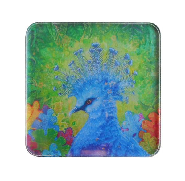 A square magnet with rounded corners featuring a colorful artistic illustration of a blue peacock against a green and yellow background.